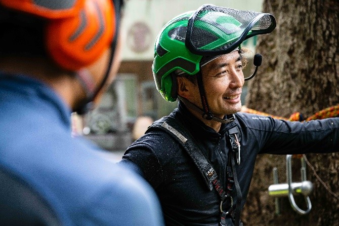 仕事中に仲間と打ち合わせる吉岡さん