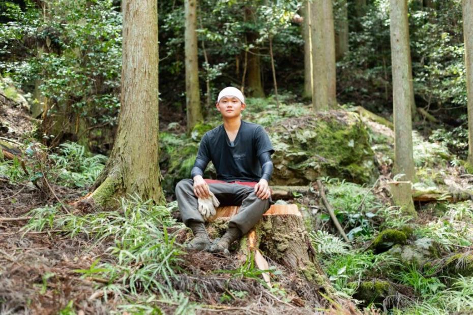 切り株の上に座ってこちらを見つめる中屋敷さん